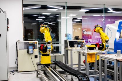 Braços robóticos operam em um ambiente industrial moderno de controle e produção.
