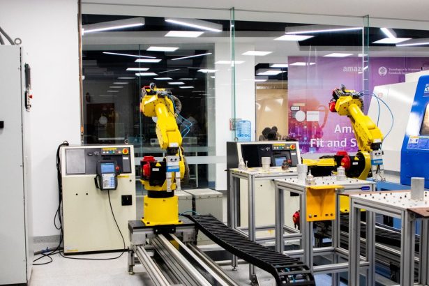 Braços robóticos operam em um ambiente industrial moderno de controle e produção.