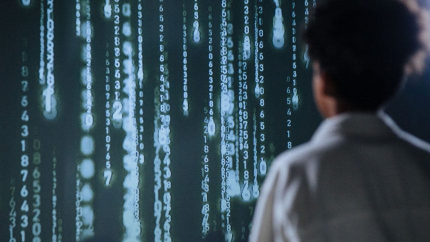 Pessoa observando números iluminados em uma tela, em uma representação de tecnologia e análise de dados.