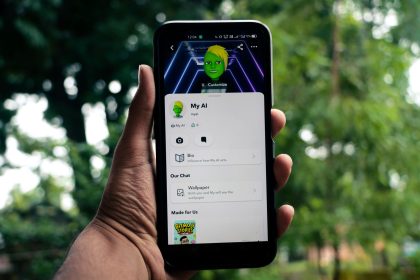 Pessoa segura um smartphone que exibe um aplicativo de inteligência artificial em um ambiente externo com vegetação.